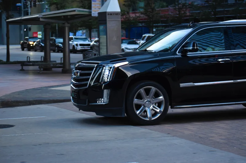 A black premium SUV on a city street at night