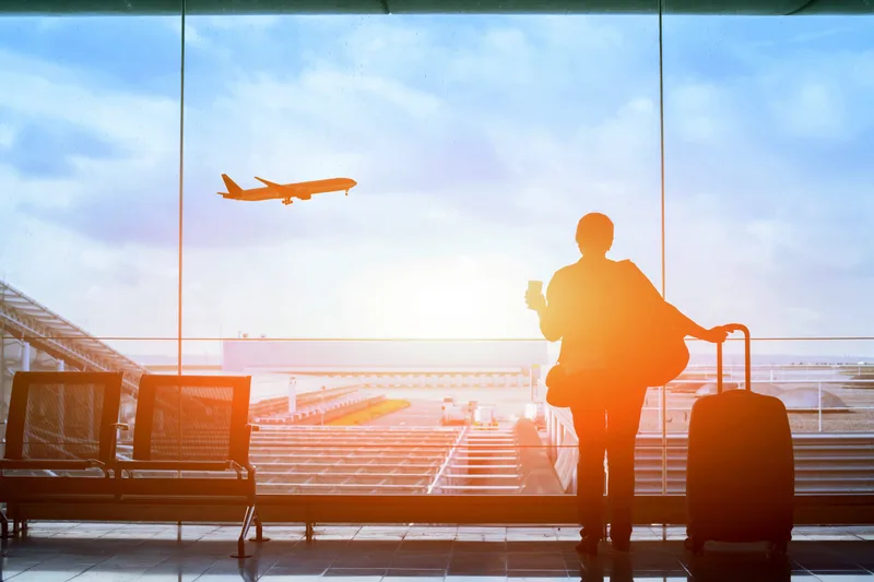 A traveller with luggage inside an international airport terminal